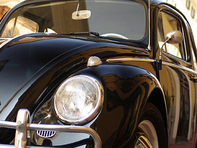 Ein schwarzer Volkswagen Käfer, frontal aufgenommen.
